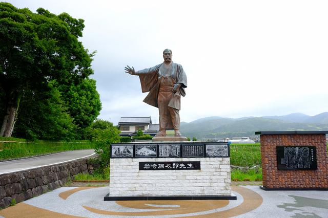 画像: 武家屋敷から田園風景の中をさらに10分ほど走ると「岩崎彌太郎生家」へと到着します。大きな銅像が迎えてくれました。三菱グループ創業者である岩崎彌太郎は、海運業で大成功をおさめ三菱財閥の礎を築きました。