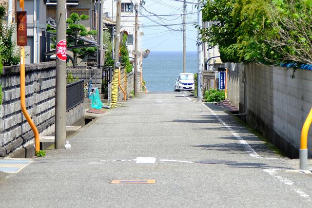 画像: 船守神社から黒崎の浜を目指して住宅街を歩きます。道の向こうに海が見えてきて、素敵な景色です。