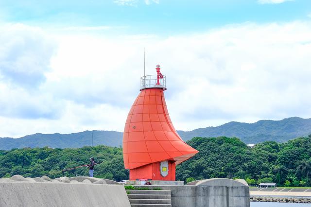 画像: 西防波堤灯台に到着しました。風に帆をなびかせる赤いヨットです。