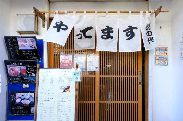 画像: オープン前からすでに行列ができ始めた店外。入口にあるボードに名前を書いて開店時間まで待ちます。