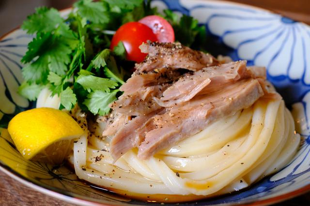 画像: エスニック風味の「パクチーまぐろうどん」。自家製ツナにはブラックペッパー、その横には山盛りパクチー。食べる直前にぎゅっと絞るレモンの香りが広がります。
