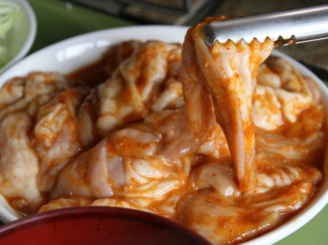 画像: ホルモンはさまざまな部位が入っている。味噌ニンニクだれに浸かる