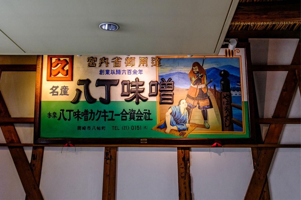 Image: A signboard that was hung at Okazaki Station during the time of the former Japanese National Railways. It depicts the story of Toyotomi Hideyoshi (Hiyoshimaru) and Hachisuka Koroku Masakatsu, who met at Yahagi Bridge.