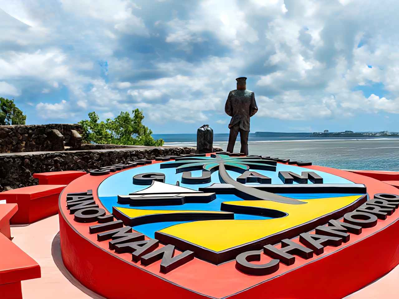 画像: 知事複合施設内にあるグアムの印章。奥に見えるのは全米で16番目にあたる海軍記念碑のLone Sailor像