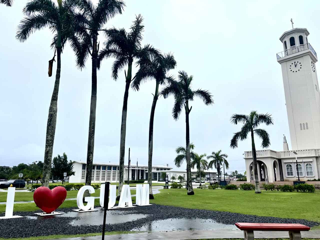 画像: 「I LOVE GUAM」モニュメントの右手奥に見える時計塔と聖母マリア大聖堂