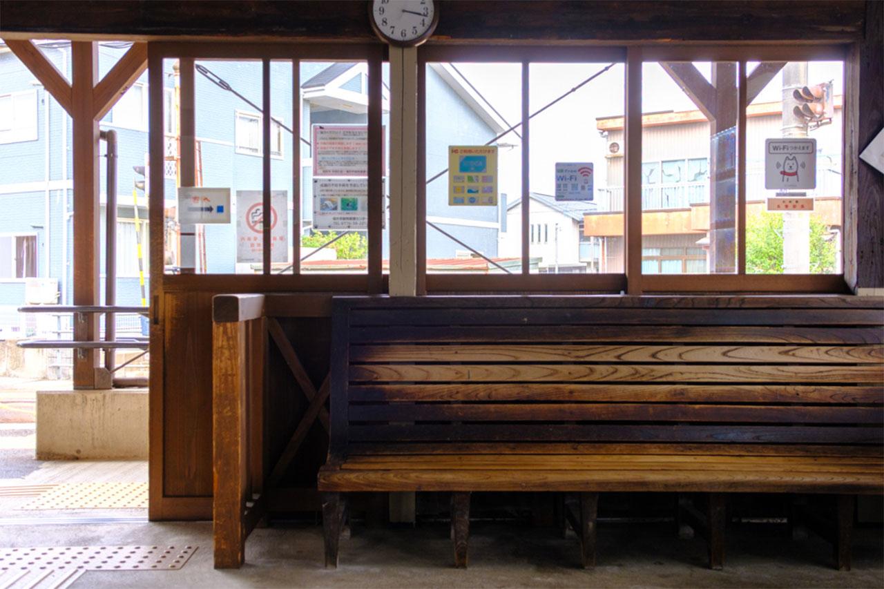 画像: 時を重ねてあめ色になった木造ベンチ。待合室で今も現役。