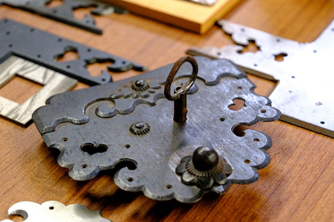 画像: 伝統的な金属加工技法「真綿焼き」。熱した鉄に絹（真綿）をすりつけて表面を変色させ、黒く仕上げる