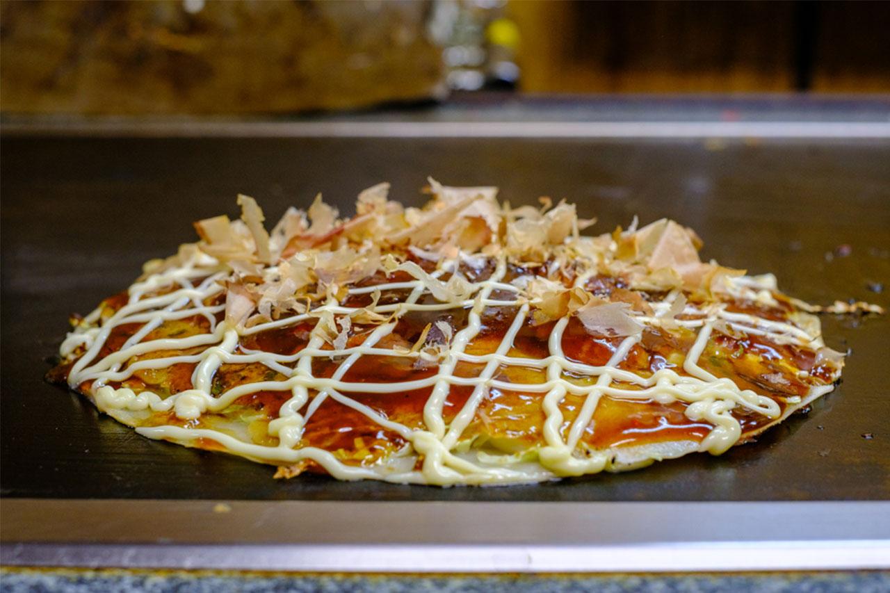 画像: ウスターソースを塗った後、オリジナルのブレンドソースをかける。マヨネーズとおかかで仕上げ