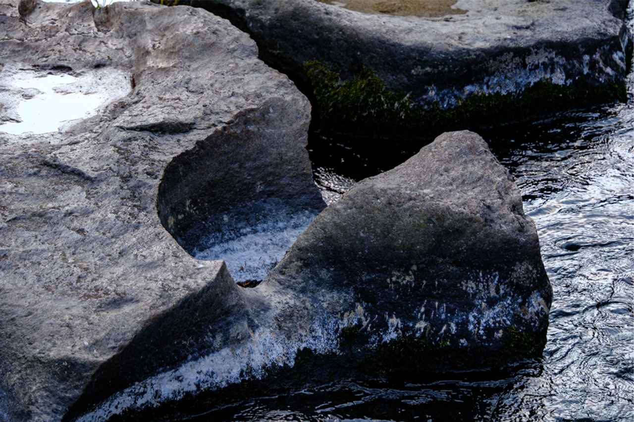 画像: 甌穴とは、水流で石や砂が回り続け、岩を削って生まれた丸い穴のこと。