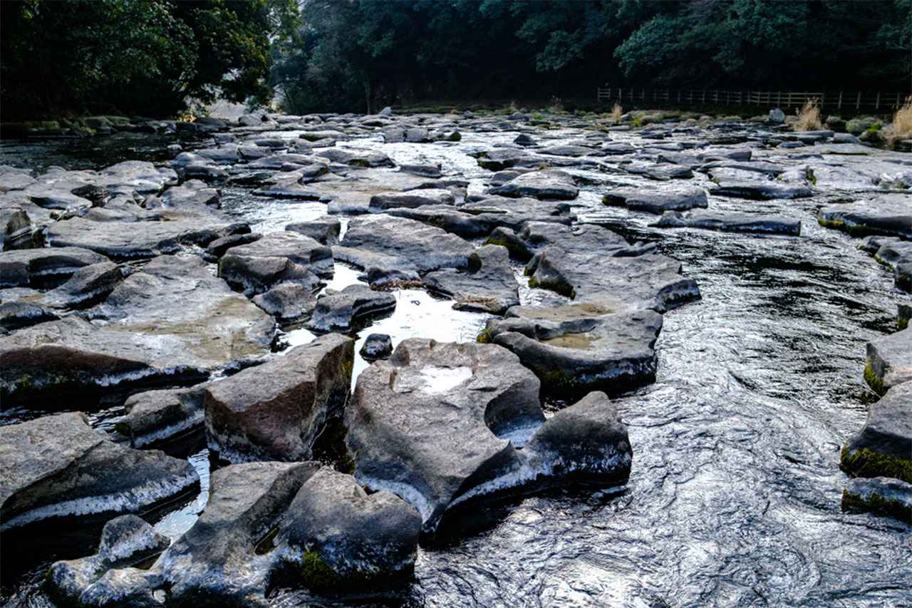 画像: 関之尾滝では、溶結凝灰岩の河床が削られて生まれた甌穴が滝まで連なり、ここならではのダイナミックな風景をつくり出している。