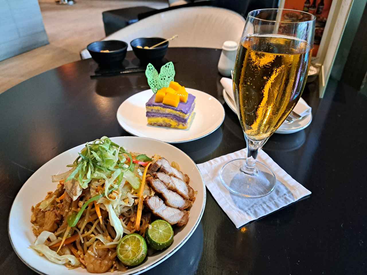 画像: 2種類の麺を使い、鶏肉・豚肉・エビなどの具がたっぷりの「パンシット」に、すだちのようなフィリピンの柑橘「カラマンシー」をしぼるのが現地流の食べ方。ウベ・マンゴー・サンスリバルはナッツ入りのメレンゲ、ウベ（紅山芋）とマンゴー風味のバタークリームが層になっており、その濃厚な食感と甘さに驚くかもしれません。