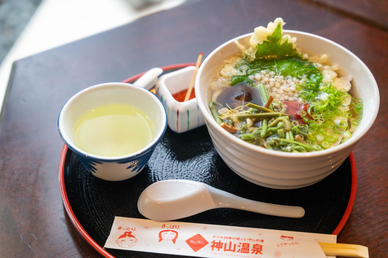 画像: 神山温泉うどん」（957円）は、梅、すだち、神山鶏、神山椎茸、そば米など、神山の食材をすべてトッピングした、ここならではの一杯