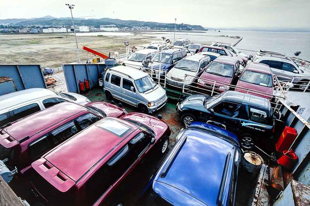 画像: 日本を出港する前の「RUS」号。甲板にも車両を満載するために、クレーンを使用していたのだ。大量の中古車。