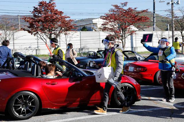 画像: 一台一台を誘導して参加者からチェックシートを回収