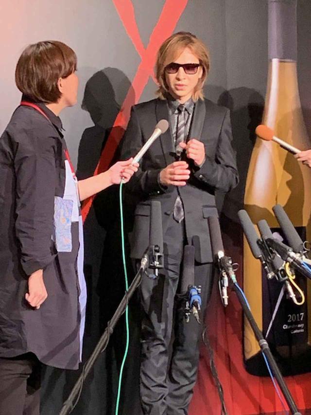 画像: 囲み取材では、いろいろな質問が飛び交った。X JAPANのニューアルバムについて聞かれると「絶対言われると思った(笑)。今、樽から抜けて瓶の中に入っているくらいです」とワインに例えて答えた