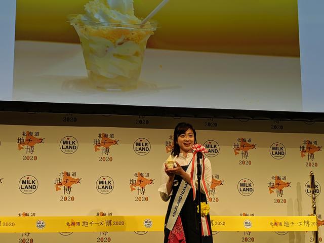 画像: 北海道地チーズソフトクリームを試食する黛英里佳さん