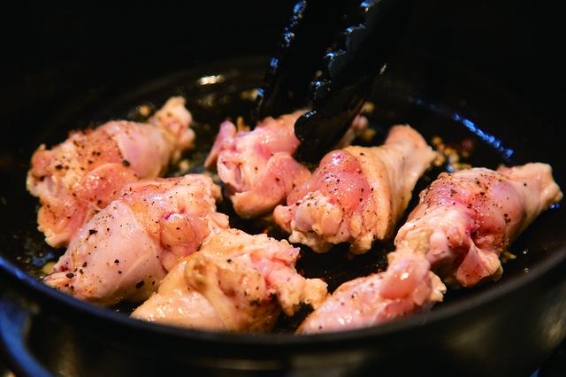 画像: 鶏肉は、肉の旨味が流れ出ないように皮目から焼く。出てきた油は必ずふき取る。そうすることで、すっきりとした味に仕上がる