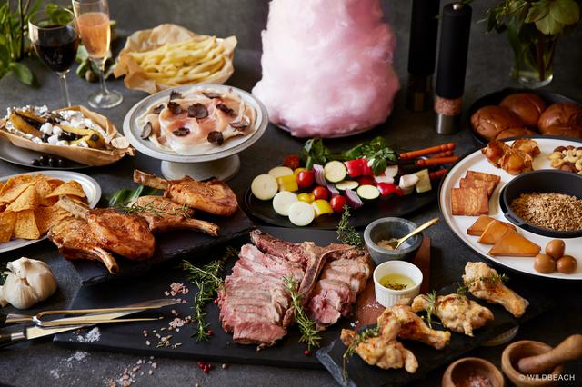 画像: Tボーンステーキを中心に肉料理が並ぶ。高さ40センチのファイヤーコットンキャンディも圧巻