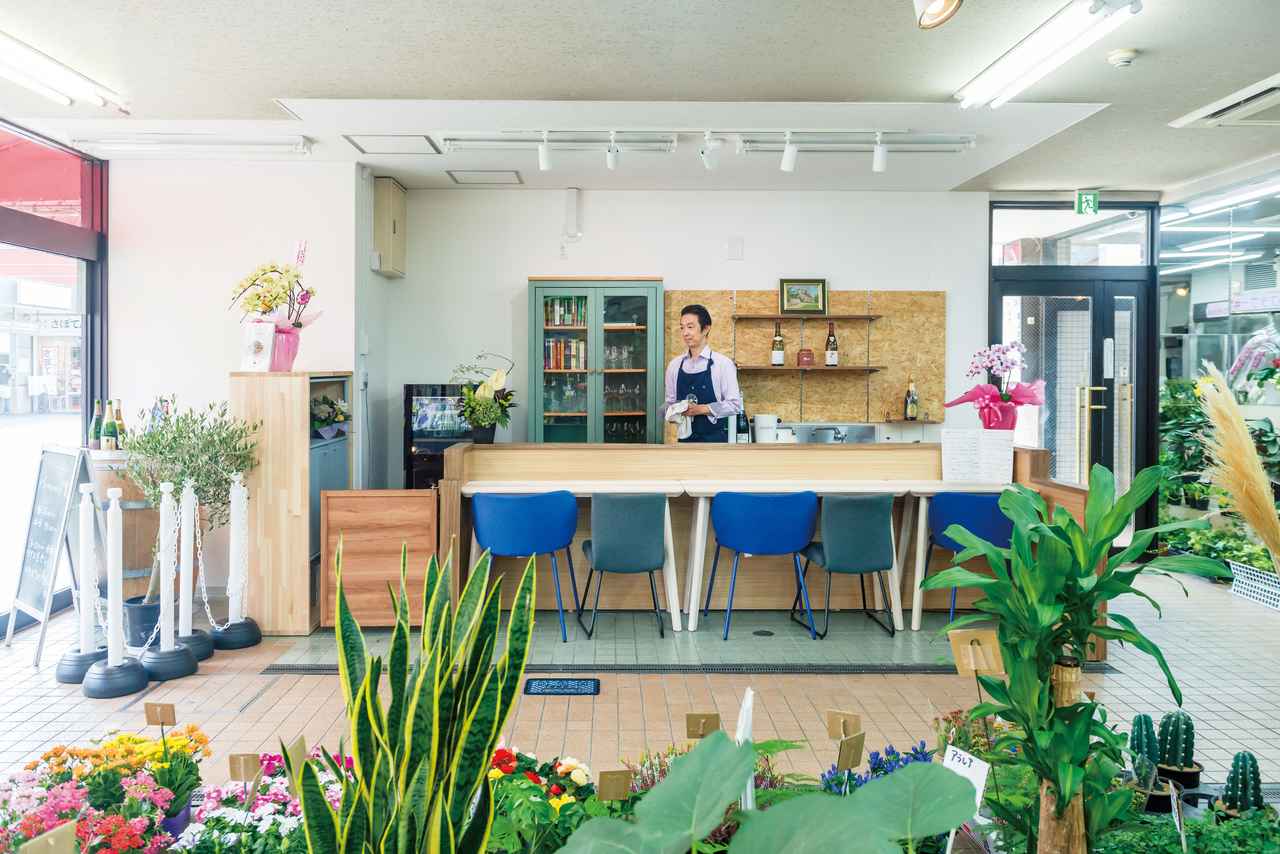 画像: 市場の共用スペースとの仕切りになる壁はないが、木目調の設えに柔らかなグリーンとブルーが効いた店は周りともなじむ。「自然豊かな故郷、大分県佐伯市をイメージしました。ここは私の原点回帰の場」