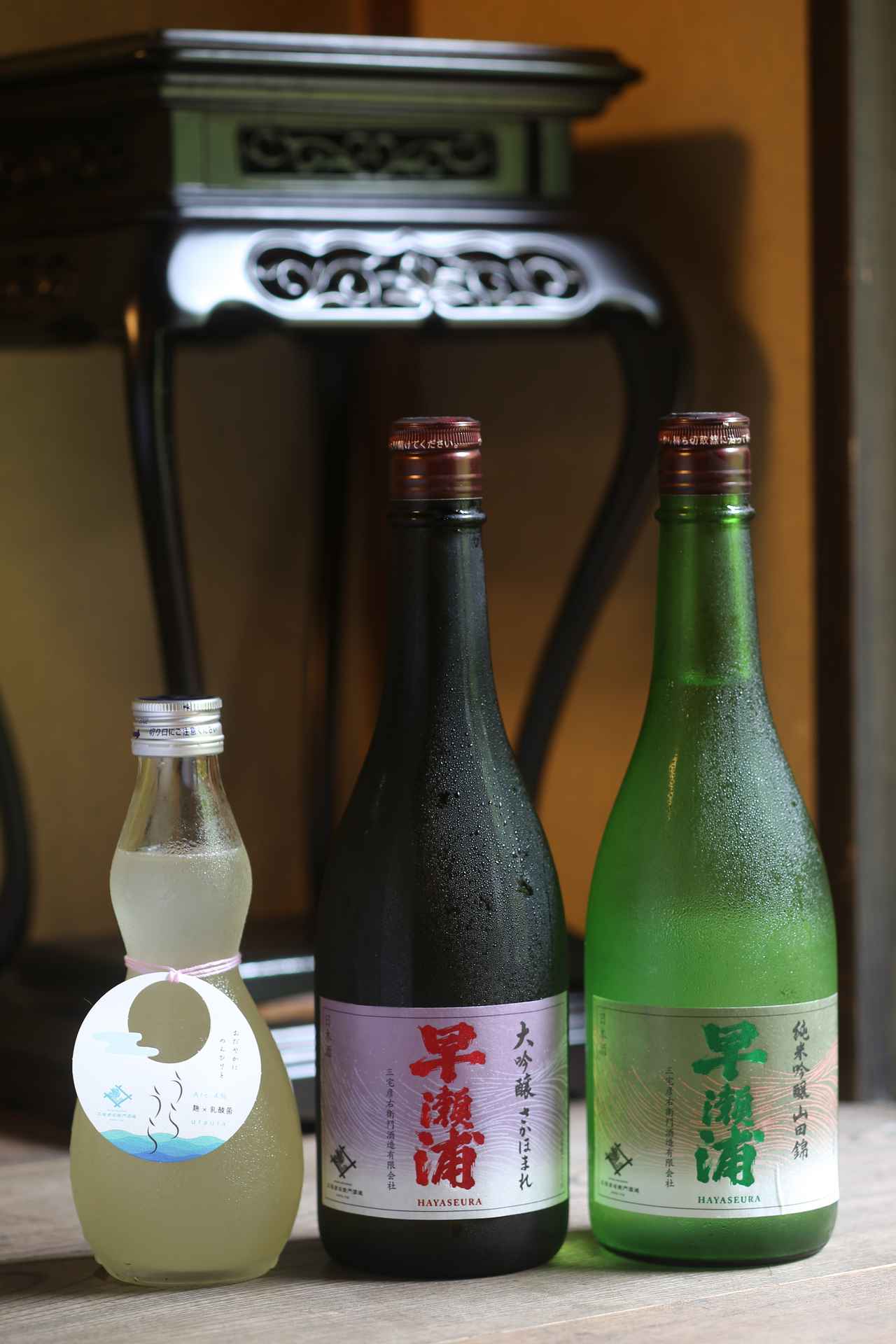 画像: 『早瀬浦特別純米酒うらうら おりがらみ』。乳酸菌を使った低アルコール酒で甘酸っぱくやさしい味わい（写真右）。『早瀬浦 大吟醸 さかほまれ』『早瀬浦 純米吟醸山田錦』は、旨味と軽やかさを持ち合わせる。「漁師の町だから、たくさん飲めて翌日残らない酒が一番」と三宅氏はニッコリ