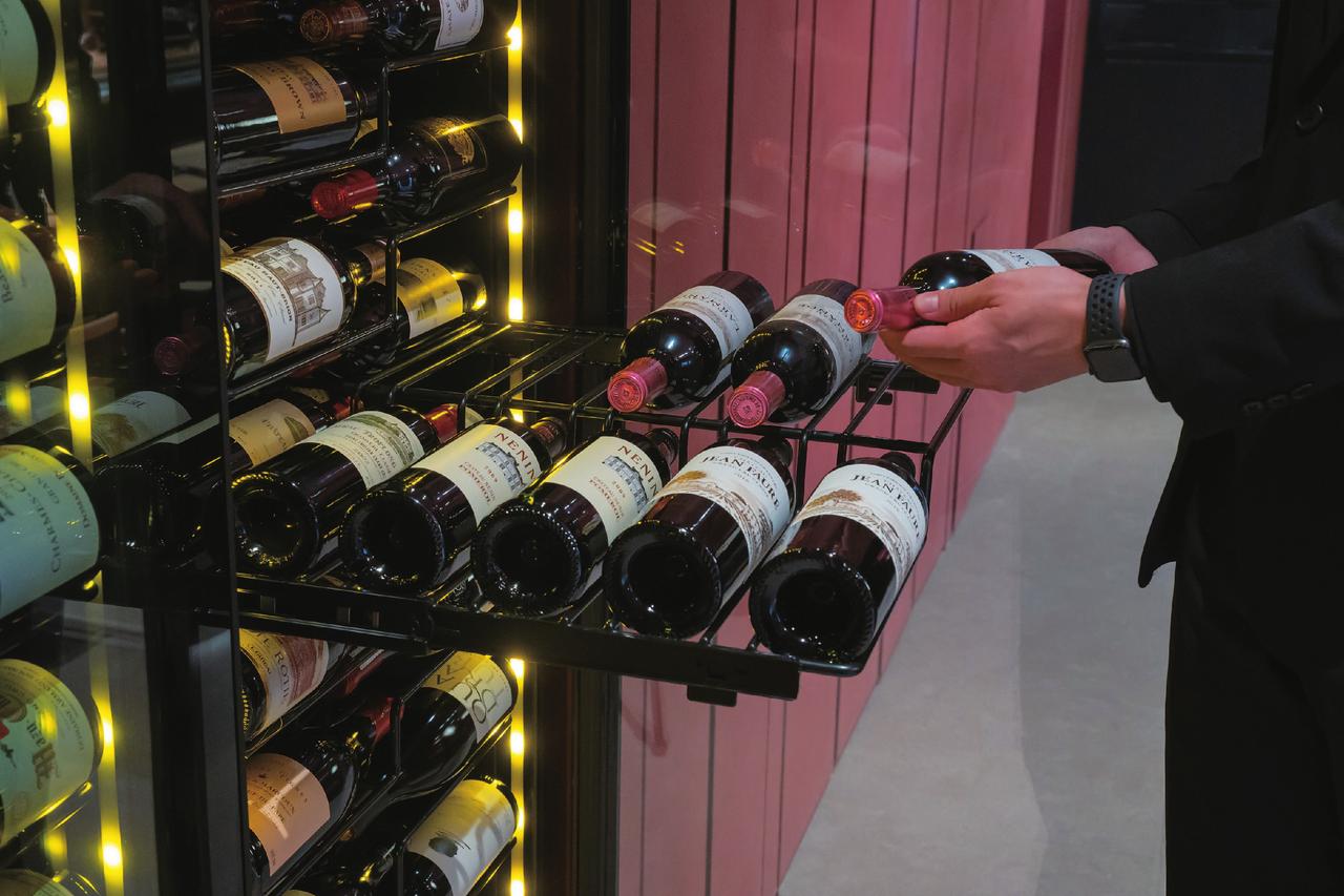 画像: 国際特許取得の特殊ラックは高さを違え1段で12本を収納(直径86mmまでのボトル。最下段は8本)。スムーズに手前まで引き出せ、奥のアイテムも取り出しやすく、提供もスピーディー