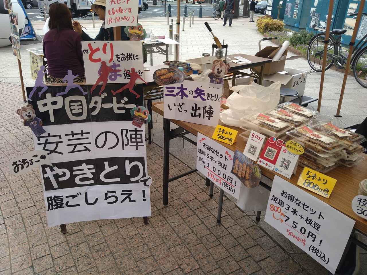 画像 : 3番目の画像 - 【写真】スタジアム近くのJR横川駅では初ダービーを記念して応援イベント『中国ダービー応援祭り IN 横川』を開催。地元のパン店が考案した限定メニュー、焼鳥店の応援セット、缶バッジづくりなどで盛り上がった - サッカーマガジンWEB