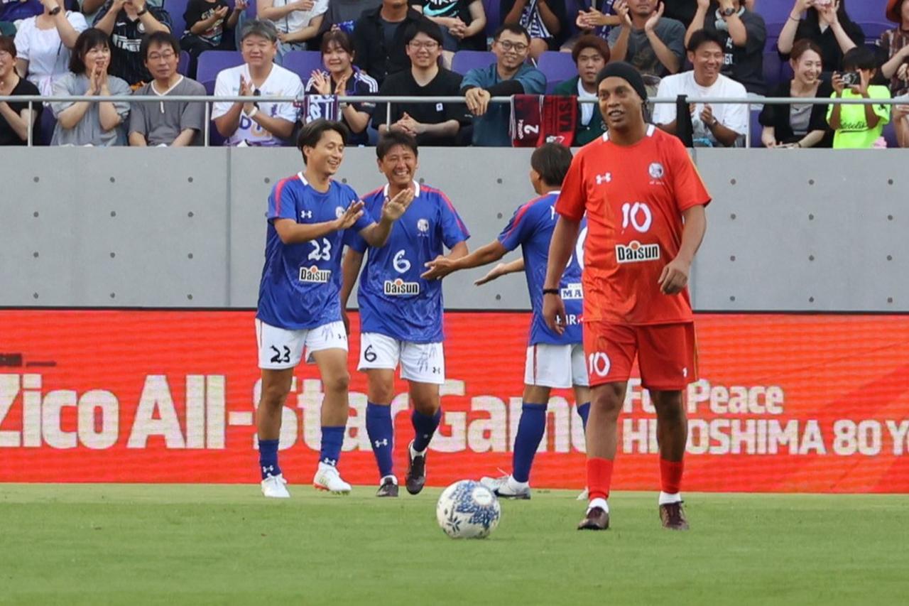 画像 : 9番目の画像 - 【写真】試合前には日本代表の森保一監督からメッセージ動画が流され、アイドルグループ・STU48によるオープニングアクトも。往年の名選手が広島の地で競演した。試合後はモネールと中澤佑二の「お尻ぶつけダンス」も！（写真◎石倉利英） - サッカーマガジンWEB