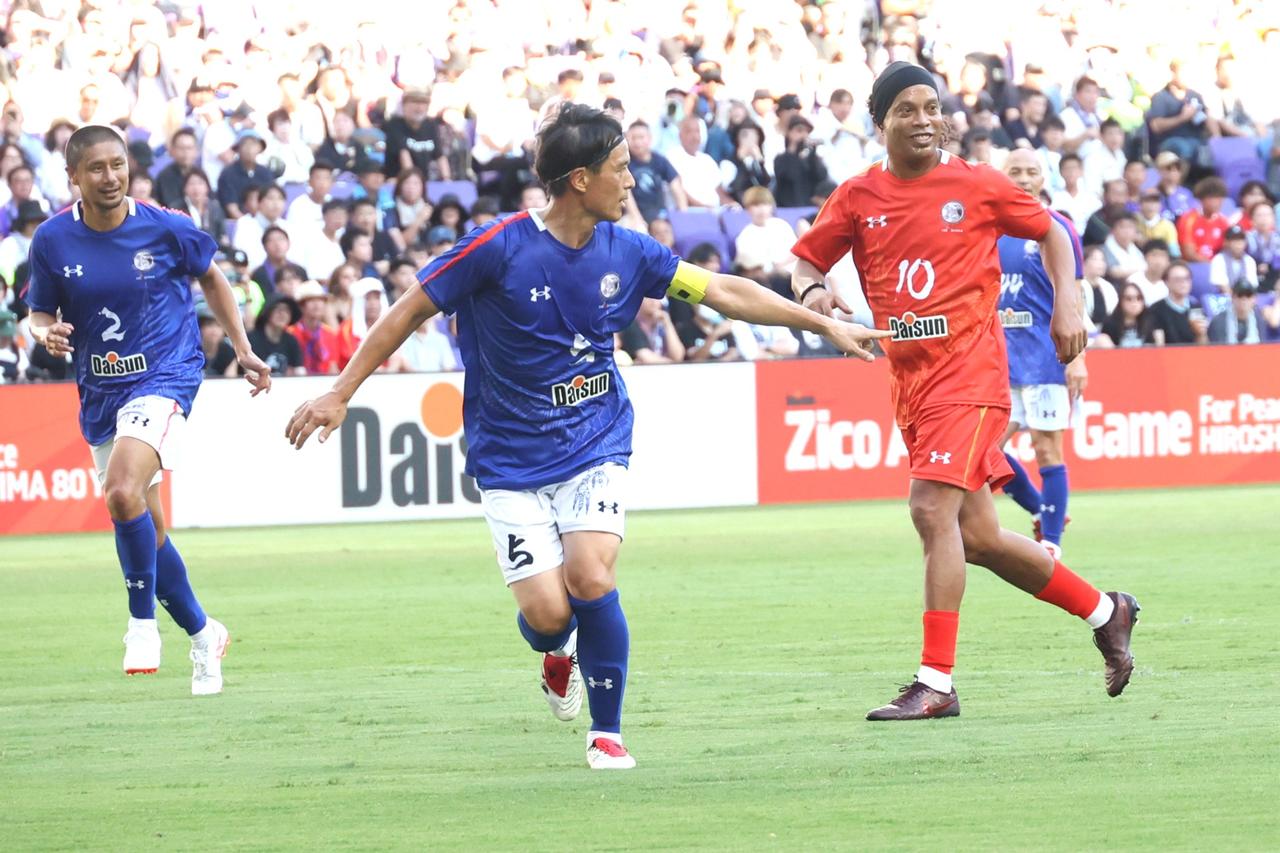 画像 : 1番目の画像 - 【写真】キャプテンマークを巻いてフル出場した宮本会長。ロナウジーニョと激しく競り合い、セットプレーから得点も狙った（写真◎石倉利英） - サッカーマガジンWEB