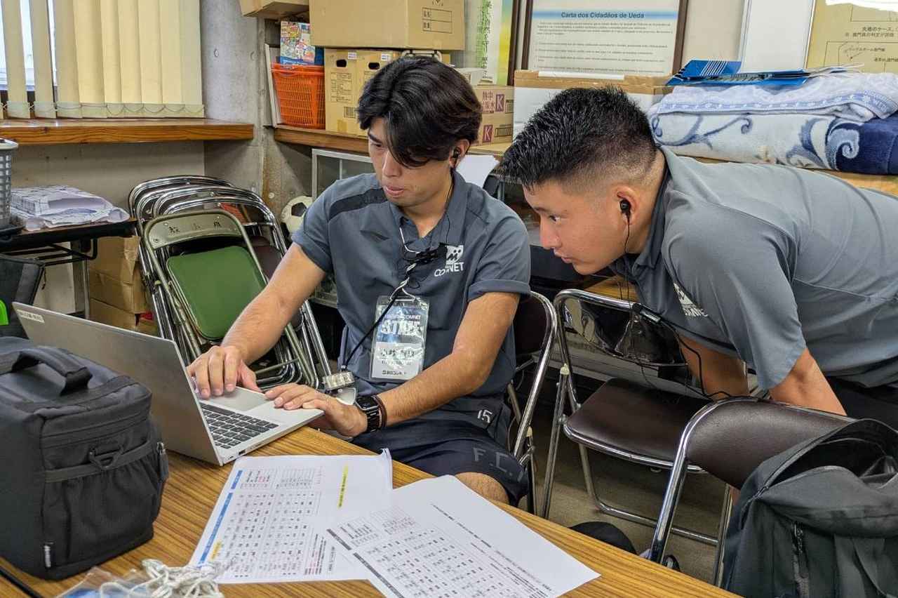 画像: サッカーマガジンカップの期間中、先輩社員に聞きながら業務をこなす。Jリーグでの経験を社会人生活に生かし、成長を期している（写真◎石倉利英）