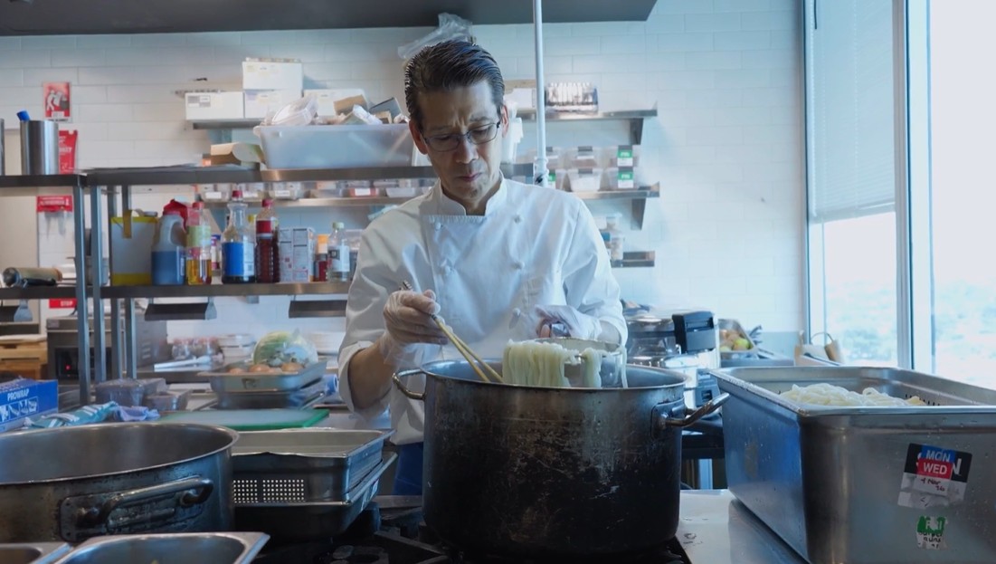 画像: 大会期間中の食事を用意している西シェフ。試合前に食べるうどんをゆでています（写真◎JFA/PR）