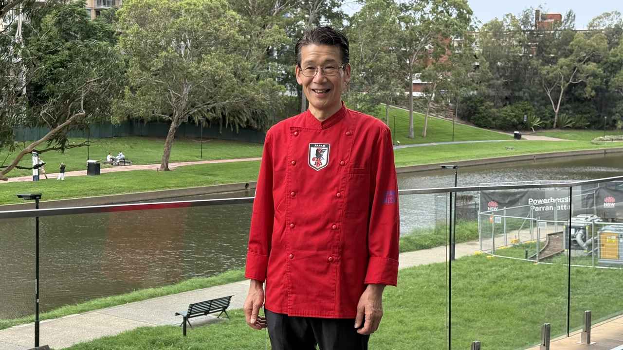 画像: 鮮やかな赤のコックコートで笑顔の西シェフ。日本代表に欠かせない存在です