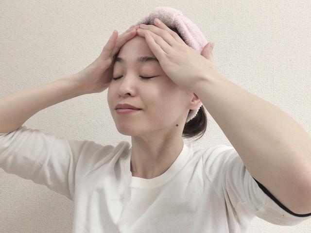 画像: 顔の筋肉を持ち上げるイメージで、ゆっくりとおでこを通って生え際まで手を滑らせます。この動きを10回ほど繰り返します。