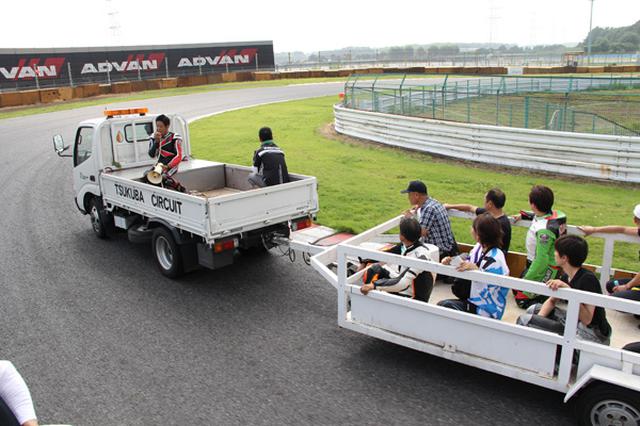 画像: レッカー車に乗って生身さんの説明を聞きながらをコースを巡り、コーナーではコースに降りて講師の走行を間近に見ながら説明を聞く
