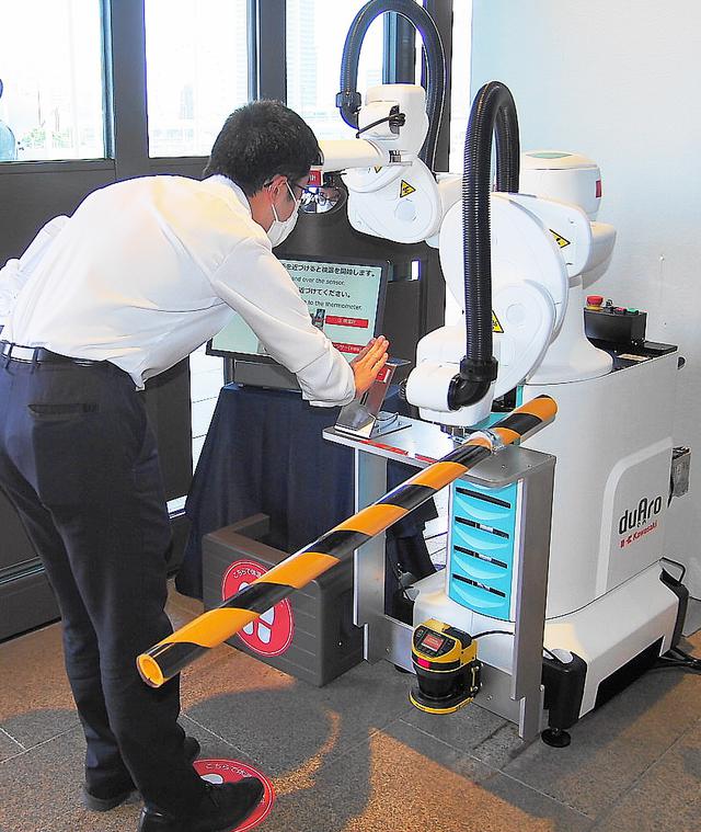 画像: 入館の際はカワサキ製ロボットが自動検温を行う