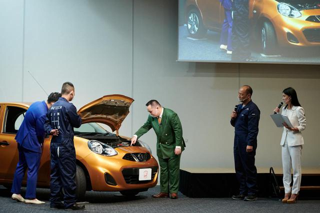 画像: 整備士日本一のアドバイスを受けながら日常点検デモンストレーションに臨むミルクボーイの2人