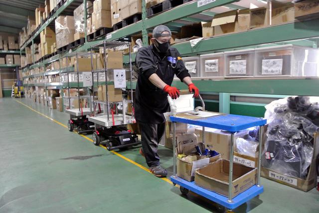 画像: 広い倉庫を搬送用ロボットが巡回し、人的移動時間を削減