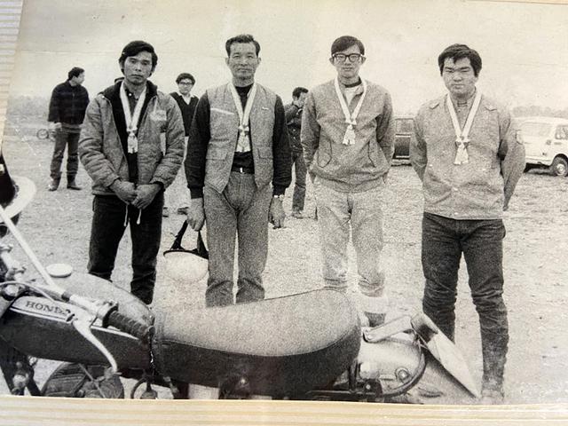 画像: 1972年のMCFAJ全日本トライアル選手権大会において3位で表彰される浅賀さん。表彰者は右からヤマハ発動機(入社前)の木村治夫さん、本田技研工業の田中よしあきさん、同・稲田実さん。いずれのメンバーもその後トライアルの普及に尽力した人たちだ