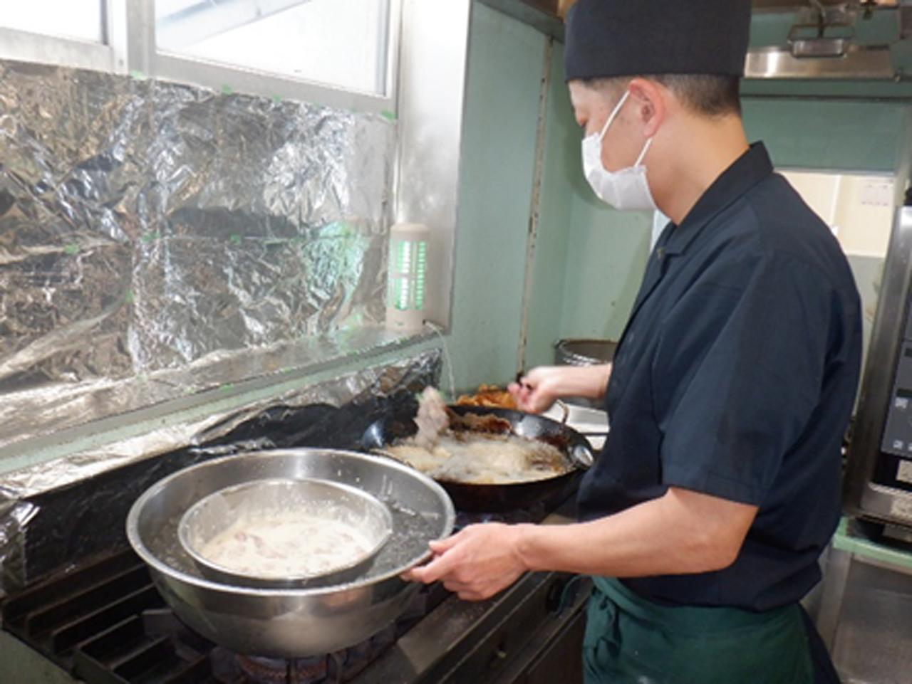 画像: メニュー作成時などは栄養士の調理指導のもと、数人で和気あいあいと作業をすることもあるが、調理中は基本1人なので、黙々と作業に明け暮れることになるという
