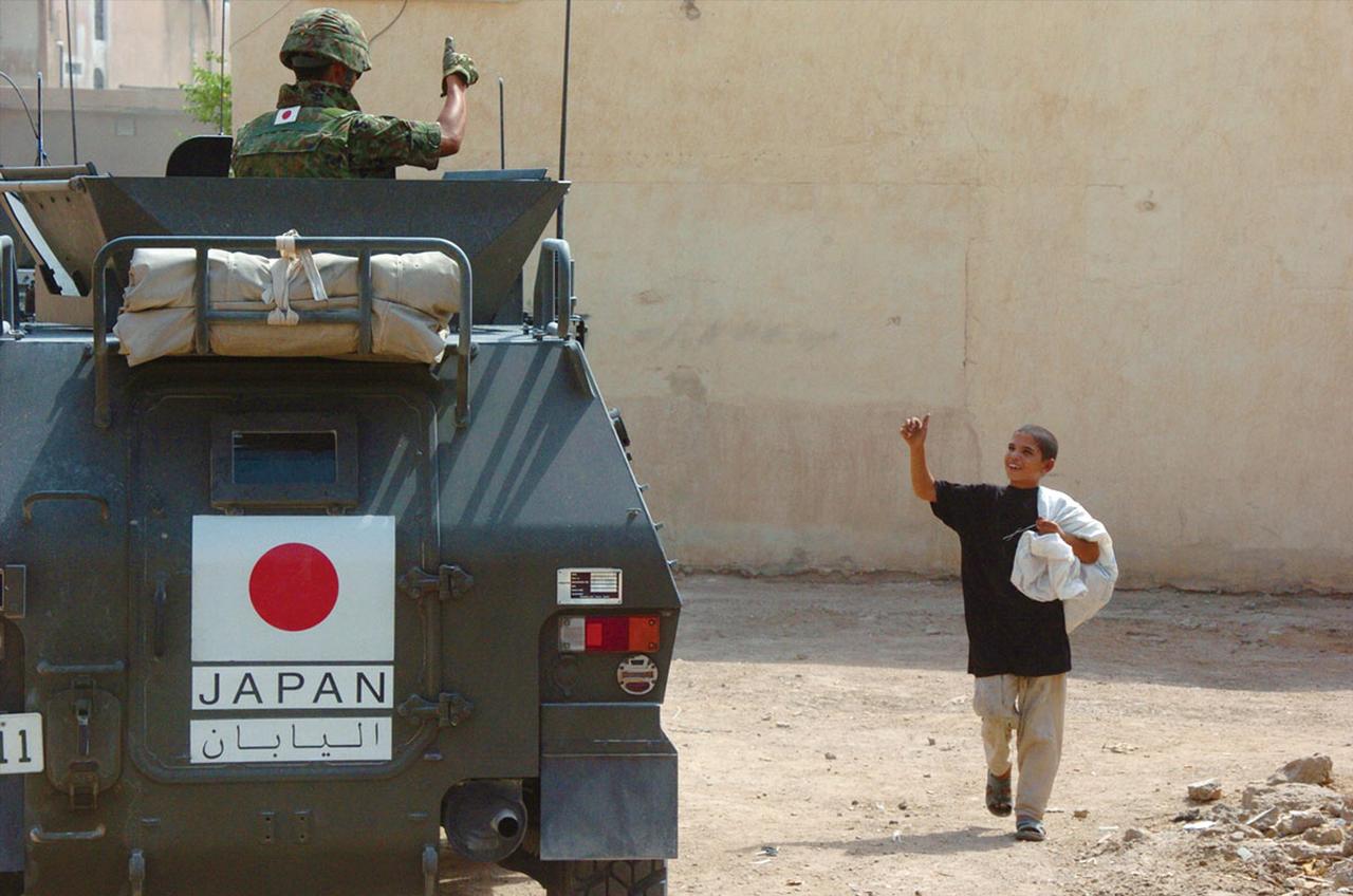 画像: イラクで地元住民との交流を深め、信頼関係を構築したイラク復興業務支援隊。市中を走行する際に現地の子どもに親指を立てるジェスチャーであいさつをする