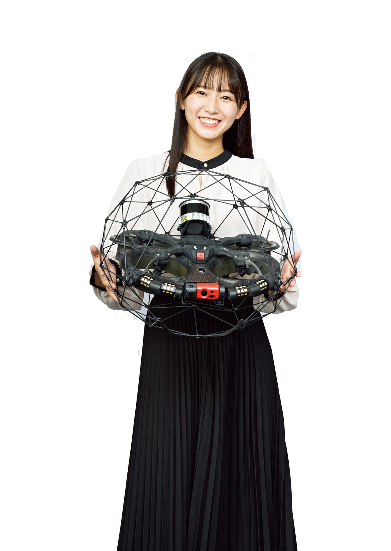 画像: 室内用のマルチコプター・ドローン（ヘリコプタータイプ）を持つ志田さん　機体提供／株式会社ブルーイノベーション