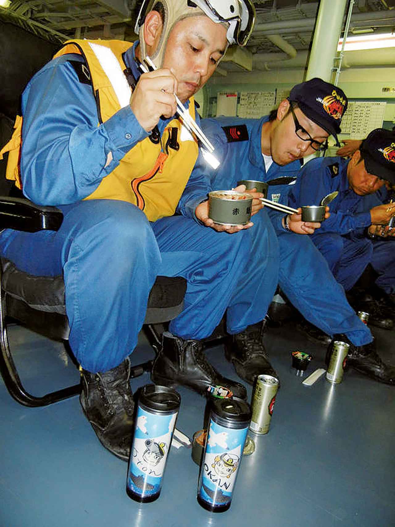 画像: 海上自衛隊艦艇の訓練中の食事。通常は食堂で食事をとるが、訓練時は各自の持ち場で缶詰などの食事をとることもある