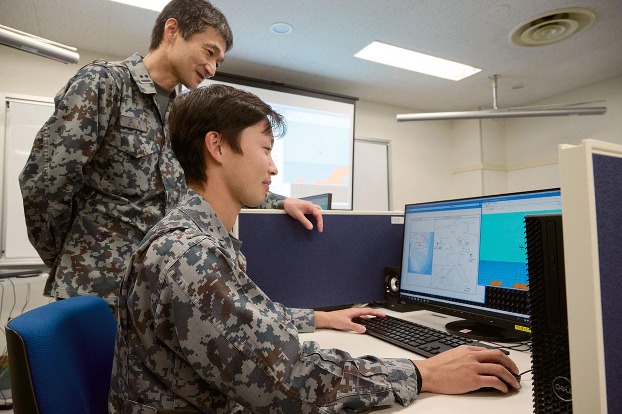 画像: 「教育」では、講義用の表示装置（モニター）を使用した座学と、電子戦用の器材を用いたシミュレーションを行う実習によって教育が実施される