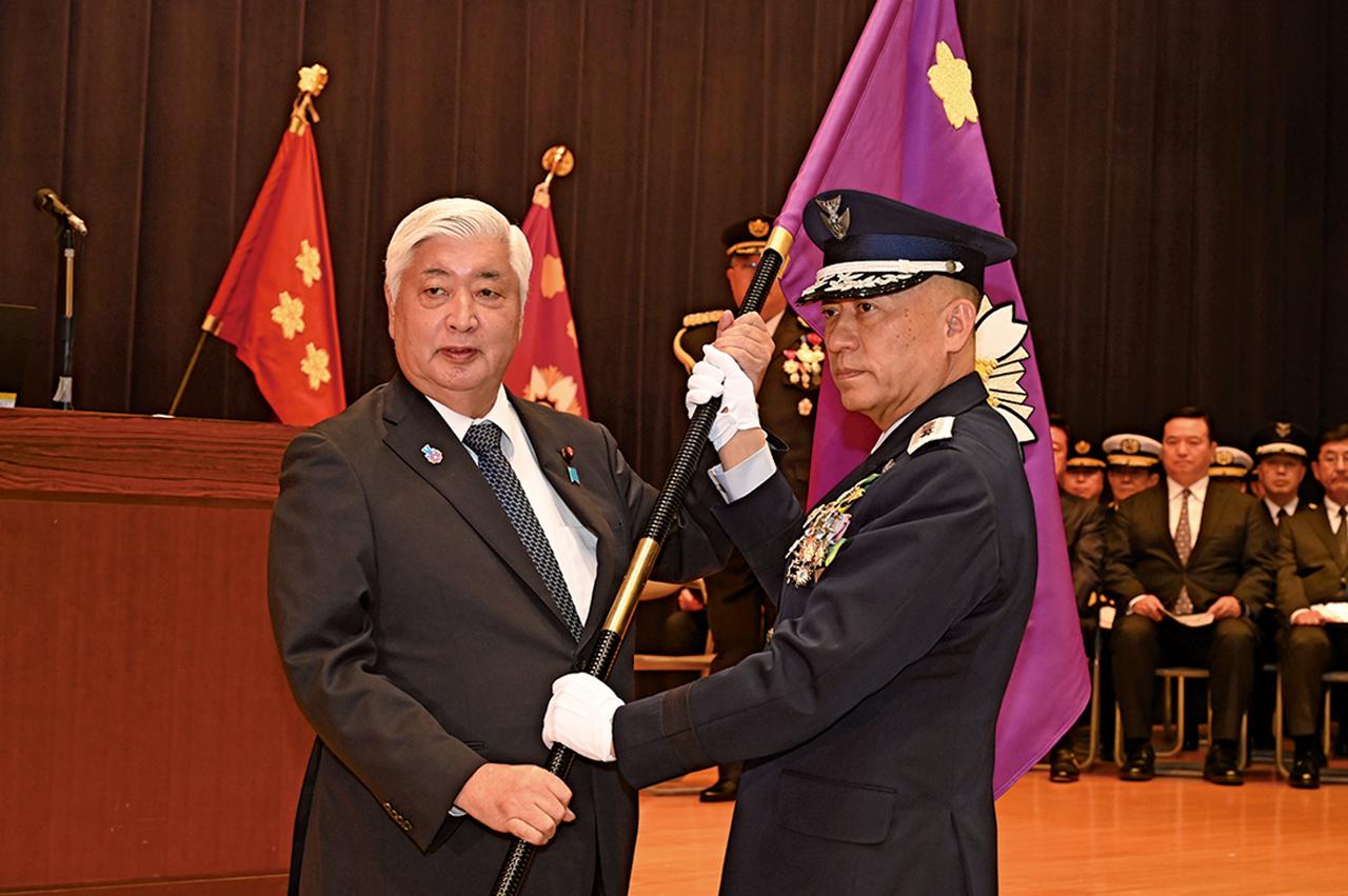 画像: 2025年3月24日に行われた編成完結式では、初代の統合作戦司令官に着任した南雲空将(右)に、中谷防衛大臣から司令官旗が手渡された 写真提供/防衛省