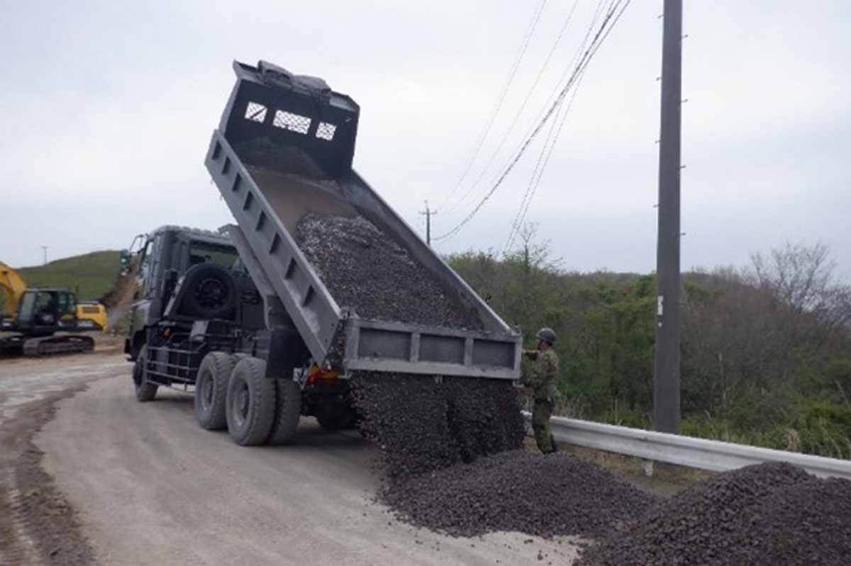 画像: 重機で土砂を運搬する隊員ら。戦闘部隊や輸送部隊が使用する路面の整備などを支援する