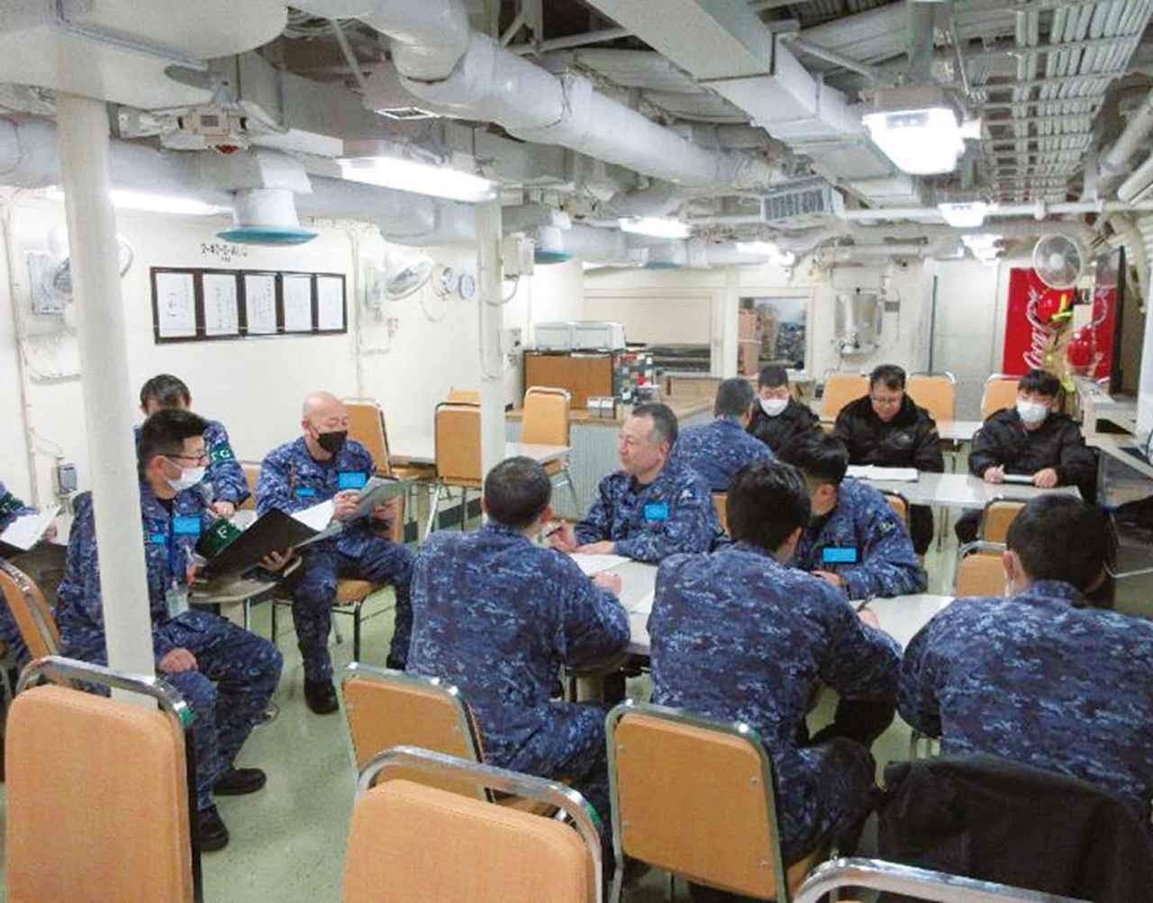 画像: 訓練後のフィードバックでは、左に座る指導官たちが訓練の総評と、今後の課題となる点を助言し、さらなる練度向上のアドバイスを実施