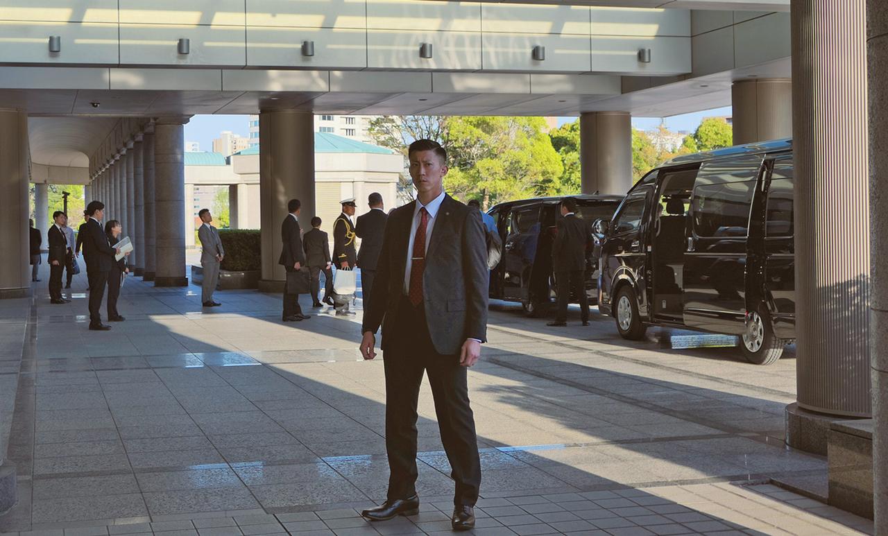 画像: トンガ王国の皇太子を乗せた専用車が防衛省から出発する際、鋭いまなざしで周囲の警戒にあたる警務隊の隊員