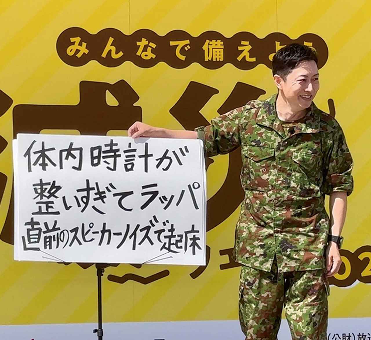 画像: イベント会場で自衛隊あるあるネタを披露する小野寺氏。ユーチューブでも自身のネタを披露して人気を博している