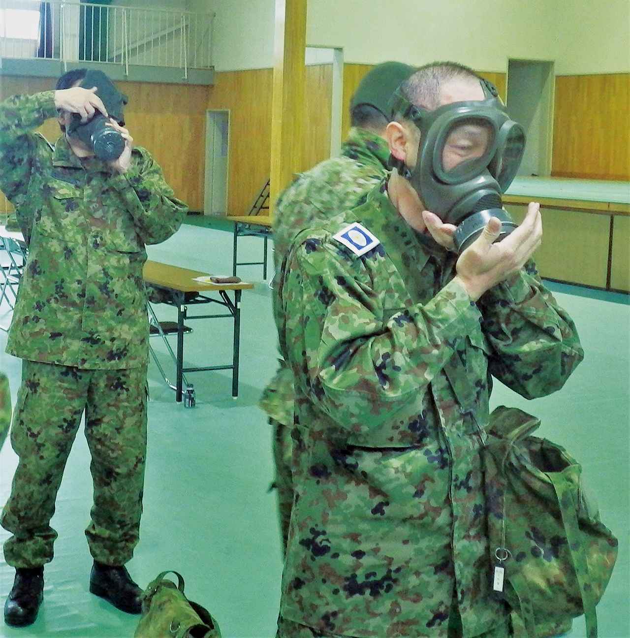 画像: 「状況ガス」の号令とともに、手早くガスマスクを着用する予備自ら。8秒以内に装着する