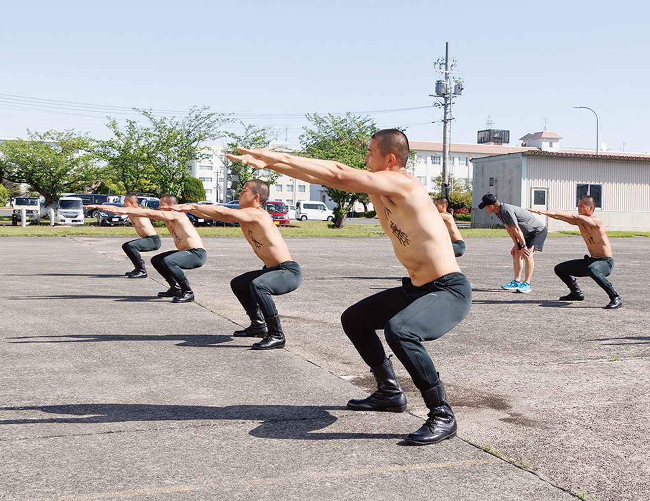 画像: 体力向上運動中は精神修養のため上半身裸。真冬でも体から湯気が出るほどの激しさだ。学生要員たちは識別のため胸と背中に名前を書いている