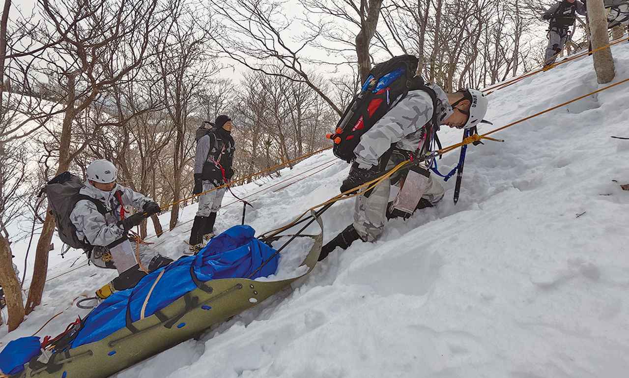 画像: 山岳での救難訓練は雪の積もった冬季にも実施。スキーやかんじきなど冬山用の装備を身に着け、要救助者をそりに乗せて搬送する訓練などを行う